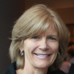 Smiling blonde woman wearing hoop earrings, looking at the camera (head-and-shoulders portrait).","Head-and-shoulders portrait of a middle-aged woman with short blonde hair." ,